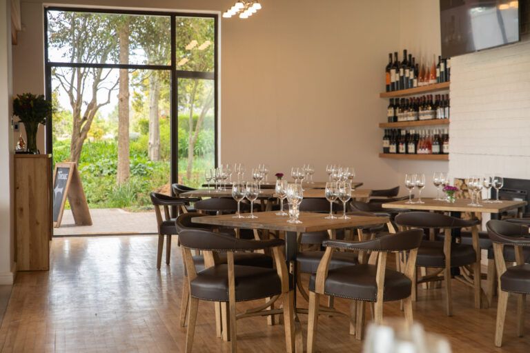 tasting room tables and chairs with a view of the outside from the glass doors