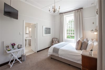 Denniston Luxury Suite accommodation view of bed, window into bathroom