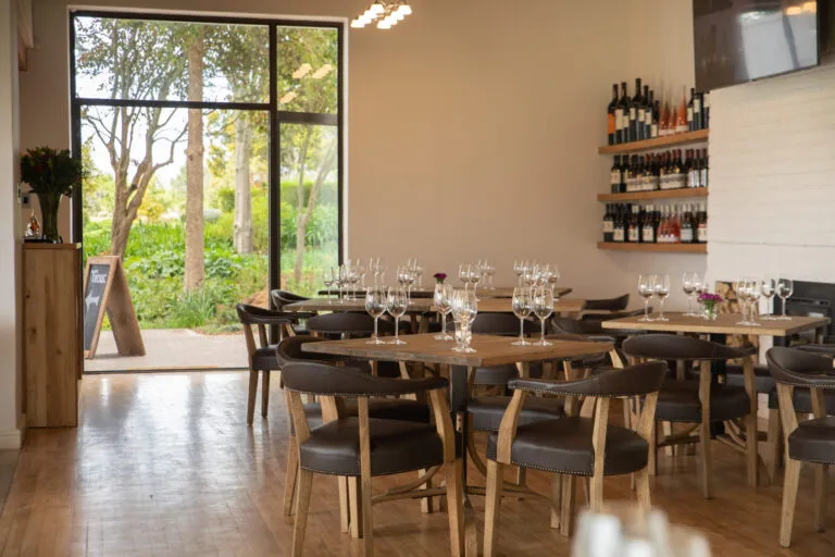 tasting room tables and chairs with a view of the outside from the glass doors
