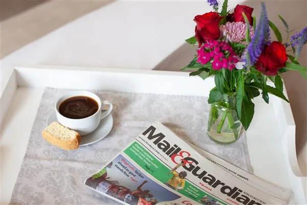 Hahn Family Suite coffee tray with coffee, rusk, flowers in vase and newspaper